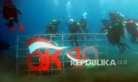 Anggota komunitas penyelam Otoritas Jasa Keuangan (OJK) dan komunitas penyelam Industri Jasa Keuangan (IJK) melaksanakan penanaman bibit terumbu karang di Pantai Malalayang, Manado Sulawesi Utara, Sabtu (16/10/2021). Kegiatan konservasi terumbu karang dengan menanam sebanyak 50 rak dengan total 1000 anakan karang di area seluas 150 meter persegi dilaksanakan sebagai bentuk komitmen OJK untuk mendukung penerapan ekonomi hijau, serta pengembangan destinasi wisata bahari Sulut yang sejalan dengan isu perubahan iklim global dalam rangka menyambut peringatan satu dasawarsa OJK. 