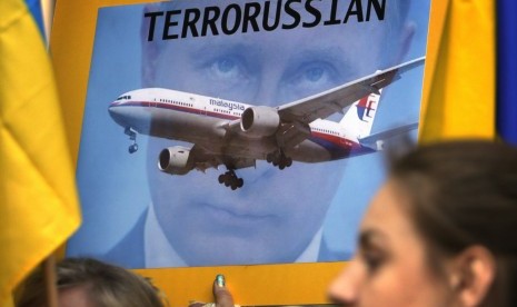 Anggota komunitas Ukraina membawa poster menolak Presiden Rusia, Vladimir Putin menghadiri pertemuan pimpinan G20 November mendatang. Mereka menyalahka Putin atas jatuhnya pesawat Malaysia Airlines MH17 