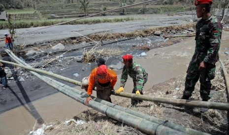 Anggota Kopassus bersama sejumlah relawan dan warga membangun jembatan darurat di bekas jembatan Klangon, Desa Pandansari, Malang, Kamis (20/2). (Republika/Adhi Wicaksono)