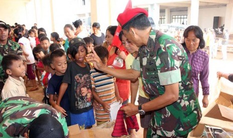  Anggota Kopassus tengah  membagikan enam karung pakaian layak pakai di rumah susun Penjaringan Muara Baru ,Jakarta Utara,Kamis (7/2).   (dok. Penerangan Kopassus)