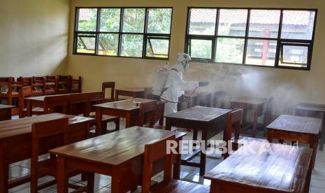 Anggota Palang Merah Indonesia (PMI) Kota Tasikmalaya menyemprotkan cairan disinfektan di ruang kelas SMA Negeri 8 Kota Tasikmalaya, Jawa Barat, Kamis (21/10/2021). PMI Kota Tasikmalaya melaksanakan penyemprotan disinfektan di sejumlah sekolah sebagai upaya pencegahan penyebaran COVID-19 selama berlangsungnya kegiatan pembelajaran tatap muka terbatas. 