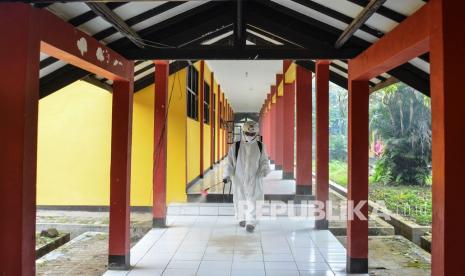 Anggota Palang Merah Indonesia (PMI) Kota Tasikmalaya menyemprotkan cairan disinfektan di selasar SMA Negeri 8 Kota Tasikmalaya, Jawa Barat, Kamis (21/10/2021). Kasus kematian akibat Covid-19 di Kota Tasikmalaya terus mengalami peningkatan. 