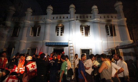  Anggota palang merah Myanmar dan warga Muslim berkumpul di luar masjid setelah kebakaran yang terjadi di Yangon, Myanmar, Selasa (2/4).  (AP/Khin Maung Win)