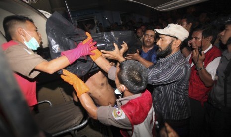  Anggota palang merah Myanmar dan warga Muslim mengangkat kantong jenazah korban kebakaran yang terjadi di sebuah masjid di Yangon, Myanmar, Selasa (2/4). (AP/Khin Maung Win)