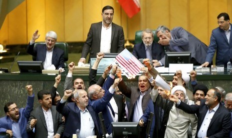 Anggota parlemen Iran membakar bendera AS.