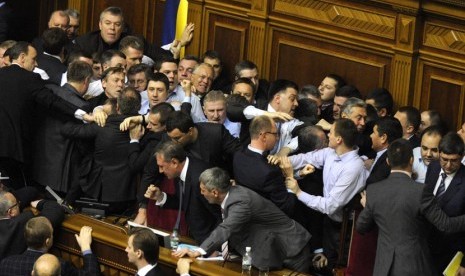 Anggota parlemen Ukraina menyerbu podium saat berlangsung sidang pertama anggota parlemen yang baru terpilih di Kiev, Ukraina, Kamis (13/12). (AP/Sergei Chuzavkov)