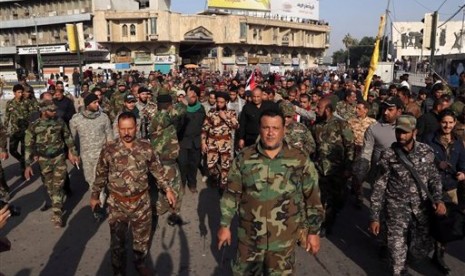 Anggota pasukan Syiah berdemonstrasi di Tahrir Square, Baghdad menuntut penarikan pasukan Turki dari Irak, Sabtu, 12 Desember 2015.