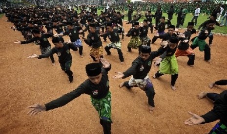 Anggota Pencak Silat Pagar Nusa Nahdatul Ulama (NU) memperagakan aktraksi bela diri di Gelora Bung Karno saat peringatan Hari Lahir PBNU ke-85, Jakarta, Ahad (17/7).