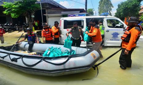 Anggota polisi bersama relawan menyalurkan bantuan untuk korban banjir di Desa Cingkrong, Purwodadi, Grobogan, Jawa Tengah, Rabu (1631/2022). Warga terdampak banjir di wilayah itu sudah mulai mendapatkan bantuan berupa makanan, minuman hingga sembako dari pemerintah maupun sejumlah lembaga kemanusian.