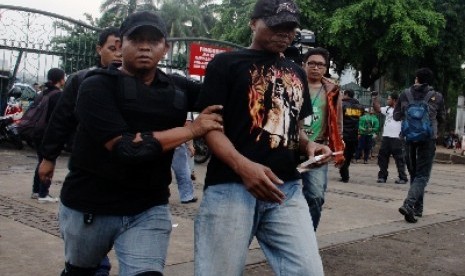 Anggota polisi dan TNI merazia preman di kawasan Monas, Jakarta Pusat, Kamis (26/6). 