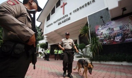 Anggota Polisi dari Mapolres Sidoarjo melakukan pengamanan di Gereja Pantekosta Elohim Sidoarjo, Jawa Timur, Kamis (28/3).