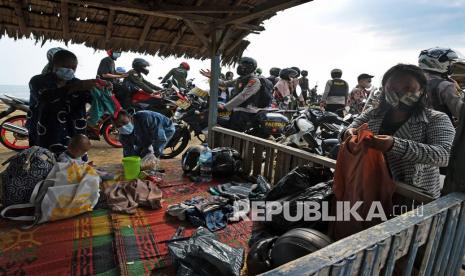 Anggota Polisi membubarkan kerumunan para pengunjung yang sedang berwisata untuk mencegah penularan COVID-19 di Pantai Pasir Putih, di Anyer, Serang, Banten, Ahad (16/5/2021). Guna mencegah penyebaran COVID-19 saat liburan pasca Lebaran Gubernur Banten memerintahkan para Bupati dan Wali Kota untuk menutup semua tempat wisata di Banten hingga tanggal 30 Mei 2021. 