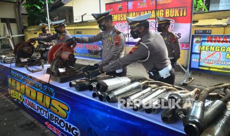 Anggota Polisi memusnahkan knalpot tidak standar atau knalpot brong di Polsek Kota Kudus, Jawa Tengah, Jumat (21/1/2022). Polisi memusnahkan sebanyak 160 knalpot brong hasil razia oleh Satlantas Polres Kudus sebagai bentuk tindakan tegas agar pengendara mematuhi tata tertib lalu lintas. 