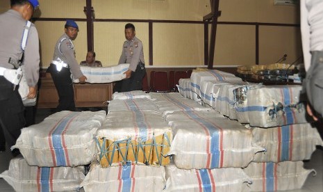 Anggota polisi menggotong karung berisi ganja bagian dari 1,7 ton ganja kering yang disita dari bandar narkoba di Serang, Banten, Rabu (2/12). 