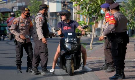 Menteri Dalam Negeri (Mendagri) Tito Karnavian menegaskan, protokol kesehatan (prokes) menjadi kunci utama untuk mencegah penyebaran Covid-19. Foto: Anggota polisi menindak warga negara asing (WNA) yang tidak menggunakan masker saat operasi yustisi Pemberlakukan Pembatasan Kegiatan Masyarakat (PPKM) Darurat di kawasan wisata Canggu, Badung, Bali, beberapa waktu lalu.