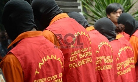 Anggota polisi menunjukkan tersangka dan barang bukti saat gelar perkara kejahatan tindak pidana penipuan online di Polda Metro Jaya, Jakarta, Jumat (9/10).