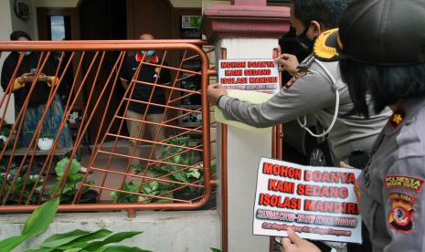 Anggota Polresta Bogor Kota menempel stiker di rumah warga yang sedang menjalani isolasi mandiri, Tanah Sareal, Kota Bogor, Jawa Barat, Kamis (4/2/2021). Berdasarkan data Satgas Penanganan COVID-19 Nasional, Kota Bogor masuk dalam zona merah berisiko tinggi penularan COVID-19 di Jawa Barat karena kasus penularan COVID-19 dalam sehari mencapai di atas 150 orang dan angka kematian mencapai tiga orang per hari.