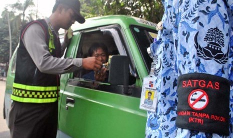  Anggota Polresta Bogor menurunkan supir angkot yang merokok saat razia Kawasan Tanpa Rokok (KTR) di jalan raya Ir. H. Djuanda, Kota Bogor, Jabar, Selasa (20/5). 