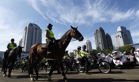 Anggota Polri berkuda dan bermotor meninggalkan lapangan seusai mengikuti apel Operasi Lilin 2015 di Polda Metro Jaya, Jakarta, Rabu (23/12).