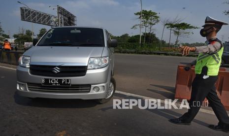 Anggota Polri mengarahkan putar balik kendaraan yang tidak dilengkapi surat izin keluar masuk (SIKM) di pintu Tol Serang Timur, di Serang, Jumat (7/5/2021). Pemprov Banten bekerjasama dengan TNI-Polri memperketat penyekatan lintas antar kota/kabupaten dan provinsi menuju Sumatera dan DKI Jakarta selama tanggal 6-17 Mei untuk mencegah penyebaran COVID-19. 