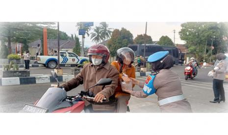 Anggota Polwan Polres Sumedang membagikan takjil gratis kepada masyarakat di depan Mapolres.