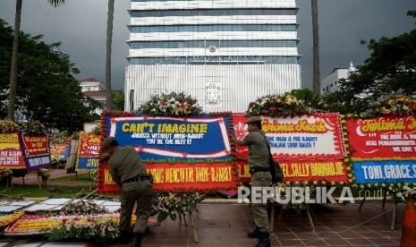 Anggota Sat Pol PP merapikan karangan bunga yang ditujukan untuk Gubernur DKI Jakarta Basuki Tjahaja Purnama atau Ahok dan Wakil Gubernur Djarot Saiful Hidayat di halaman kantor Balai Kota Jakarta, Rabu (26/4).