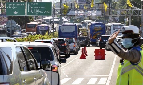 Anggota Satlantas Polres Bogor mengatur arus lalu lintas saat kepadatan di jalur wisata Puncak, Gadog, Ciawi, Kabupaten Bogor, Jawa Barat.