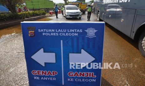 Anggota Satlantas Polres Cilegon memeriksa kendaraan roda empat saat uji coba penerapan sistem ganjil-genap (gage) menuju Pantai Anyer di Jalan Lingkar Selatan, Cilegon, Banten, Sabtu (11/12/2021). Polres Cilegon bersama Dinas Perhubungan setempat menyiapkan empat pos pemeriksaan menuju kawasan wisata Pantai Anyer guna mencegah kepadatan dengan menerapkan sistem ganjil genap (gage) setiap sabtu dan Minggu pukul 06.30 hingga 15.00 WIB selama periode tanggal 24 Desember 2021 hingga 2 Januari 2022.