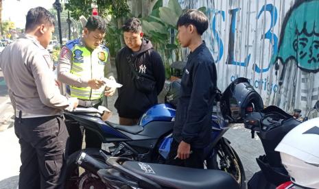   Anggota Satlantas Polres Salatiga saat menindak pemotor yang mencoba membuat konten pamer suara knalpot bising, di jalan protokol Kota Salatiga, Jawa Tengah, Ahad (11/6).