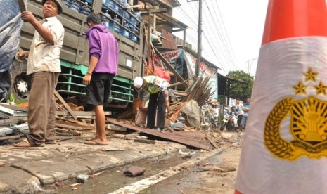 Anggota Satlantas Polres Semarang memeriksa truk pengangkut galon air mineral yang mengalami kecelakaan dengan menabrak sejumlah kendaraan dan toko bangunan di Jalan Jenderal Sudirman, depan Pasar Babadan, Kabupaten Semarang, Kamis (26/2).