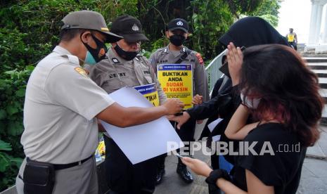 Anggota Satpol PP Kota Bogor bersama Polresta Bogor Kota memeriksa bukti vaksin warga di kawasan Pedestrian Kebun Raya Bogor, Jawa Barat, Sabtu (27/11/2021). Pemerintah Kota Bogor memberlakukan kawasan wajib vaksin dan protokol kesehatan di tempat wisata dan jalur pedestrian seputar Istana Kepresidenan dan Kebun Raya Bogor mulai Sabtu (27/11/2021) hingga berakhirnya masa libur Natal dan Tahun Baru 2022. 