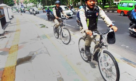 Anggota Satpol PP Kota Bogor melakukan patroli menggunakan sepeda melewati jalur khusus sepeda di pedestrian Kebun Raya Bogor, jalan Juanda, Kota Bogor, Jawa Barat, Jum'at (6/1). 