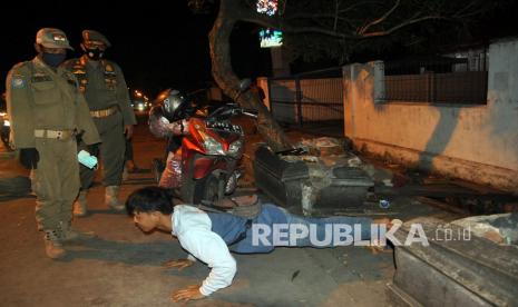 Anggota Satpol PP Kota Bogor memberikan sanksi bagi warga yang tidak menggunakan masker saat patroli jam malam di kawasan Pasar Merdeka, Ciwaringin, Kota Bogor, Jawa Barat, Selasa (1/9/2020). Pemerintah Kota Bogor memberlakukan jam malam mulai pukul 21.00 WIB dengan membatasi aktivitas warga di luar sebagai upaya menekan tingginya angka penularan COVID-19 di wilayah zona merah Kota Bogor dalam masa Pembatasan Sosial Berskala Mikro dan Komunitas (PSBMK). 