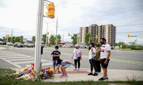 Anggota Selamati meletakkan bunga tanda berduka di lokasi penabrakan keluarga Muslim di London, Ontario, Kanada, 7 Juni 2021. Polisi mengatakan serangan tersebut merupakan kejahatan kebencian anti-Islam.