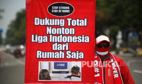 Anggota suporter Pasoepati mengusung poster Dukung Total Liga Indonesia dari Rumah Saja saat kampanye di kawasan Gladak, Solo Jawa Tengah, Jumat (12/1/2021). Kampanye tersebut bertujuan untuk mendukung rencana pelaksanaan pertandingan Liga Indonesia 2021 tanpa penonton di stadion guna mencegah penyebaran virus COVID-19.