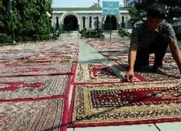 Anggota takmir masjid Sunda Kelapa tengah membersihkan karpet untuk pelaksanaan shalat Tarawih. 