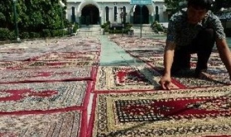 Anggota takmir masjid Sunda Kelapa tengah membersihkan karpet untuk pelaksanaan shalat Tarawih. 