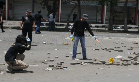 Anggota tim identifikasi gabungan dari Polres Malang dan Polda Jatim melakukan Olah Tempat Kejadian Perkara (TKP) kerusuhan di depan Stadion Kanjuruhan, Malang, Jawa Timur, Ahad (2/10/2022). 