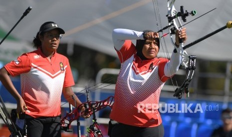 Anggota tim panahan putri Indonesia Triya Resky Adriyani (kanan) dan Yurike Nina Bonita Pereira bersiap membidik sasaran pada pertandingan Final Panahan Compound Tim Putri SEA Games ke-30 di Lapangan Parade Ground Clark Freeport, Filipina, Senin (9/12/2019).