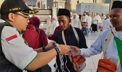 Anggota Tim Pertolongan Pertama Pada Jamaah Haji (P3JH) memberikan masker kepada jamaah haji asal Lombok di Masjid Al Haram, Jumat (19/7). 