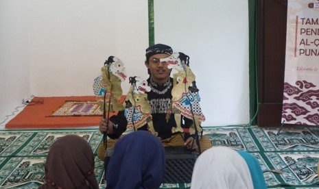  Anggota Tim PKM-M Punakawan UMY memberikan pengajaran  kepada anak-anak TPA di Masjd At Taqwa, Desa Temuwuh Lor, Gamping, Sleman.  Pengajaran ini dilakukan menggunakan media dari wayang.