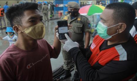 Anggota Tim Satuan Tugas Penanganan COVID-19 Kota Ternate (kanan) melakukan pengawasan dan pemeriksaan sertifikat vaksinasi COVID-19 ke penumpang Kapal Pelni KM Sinabung yang baru tiba di Pelabuhan Ahmad Yani Ternate, Kota Ternate, Maluku Utara, Senin (21/2/2022). Satgas Penanganan COVID-19 Ternate memperketat pengawasan di pintu keluar masuk di daerah tersebut untuk menekan jumlah kasus penularan virus corona, karena Kota Ternate kini berada di PPKM level III atau zona orange penyebaran COVID-19.