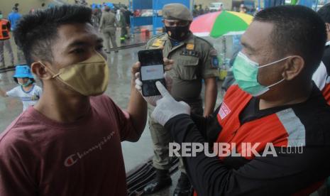 Anggota Tim Satuan Tugas Penanganan COVID-19 Kota Ternate (kanan) melakukan pengawasan dan pemeriksaan sertifikat vaksinasi COVID-19 ke penumpang Kapal Pelni KM Sinabung yang baru tiba di Pelabuhan Ahmad Yani Ternate, Kota Ternate, Maluku Utara, Senin (21/2/2022). Satgas Penanganan COVID-19 Ternate memperketat pengawasan di pintu keluar masuk di daerah tersebut untuk menekan jumlah kasus penularan virus corona, karena Kota Ternate kini berada di PPKM level III atau zona orange penyebaran COVID-19.