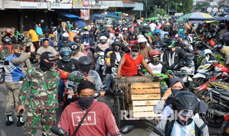 Anggota TNI AD bersama Satpol PP Kota Bogor mengatur arus lalu lintas di kawasan Pasar Anyar, Kota Bogor, Jawa Barat, Senin (18/5/2020). Kawasan pasar tradisional tersebut dipadati warga yang ingin berbelanja kebutuhan lebaran meskipun Pemerintah Kota Bogor sedang menerapkan Pembatasan Sosial Berskala Besar (PSBB) untuk mencegah penyebaran virus Corona (COVID-19). 