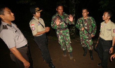 Anggota TNI bersama Taruna Tanggap Bencana (Tagana) dan Polisi berjaga di sekitar daerah longsor Dusun Dlopo, Desa Kepel, Kecamatan Ngetos, Nganjuk, Jawa Timur, Minggu (9/4).