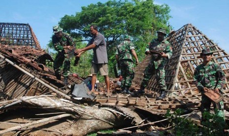  Anggota TNI bersama warga membersihkan puing rumah yang roboh akibat diterjang angin puting beliung di Desa Srikaton, Kayen, Pati, Jateng, Kamis (24/10). (Antara//Andreas Fitri Atmoko)