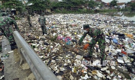 Anggota TNI berusaha mengangkut tumpukan sampah yang memenuhi muara Sungai Cikapundung di Sungai Citarum, Kampung Cigajra, Kecamatan Bojongsoang, Kabupaten Bandung, Jumat (28/10).