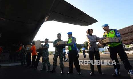 Anggota TNI dan Polri memasukkan bantuan ke dalam pesawat jenis CN-295 di Pangkalan TNI AU Adi Soemarmo, Boyolali, Jawa Tengah, Sabtu (11/8).