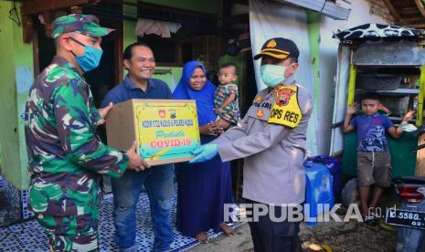 Anggota TNI dan Polri memberikan sembako kepada warga yang terkena PHK, pemudik yang kehilangan pekerjaan dan warga kurang mampu  (ilustrasi)