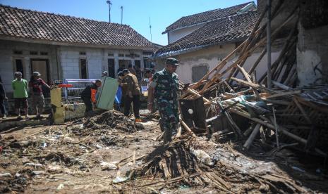 Anggota TNI dan relawan membantu menyelematkan berbagai barang milik warga pascabanjir bandang di Kampung Kaum Kidul, Ciwidey, Kabupaten Bandung, Jawa Barat, Selasa (7/6/2022). Banjir bandang yang terjadi pada Senin (6/6/2022) menyebabkan belasan rumah rusak ringan dan berat serta satu jembatan penguhubung antar desa terputus